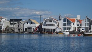 A waterfront property with multiple houses, a dock, and boats. - Åkrehamn Marina (Karmoy)