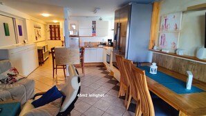 A compact living space with a sofa, a dining table, and a kitchen area. - Åkrehamn Marina (Karmoy)