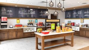 A modern kitchen with a central island, wooden cabinets, and a chalkboard wall with kitchen-related drawings.