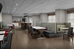 A modern hotel lobby with a reception desk, seating areas, and a "Welcome the Lone Star State" sign. - Hampton Inn Monahans (Monahans)