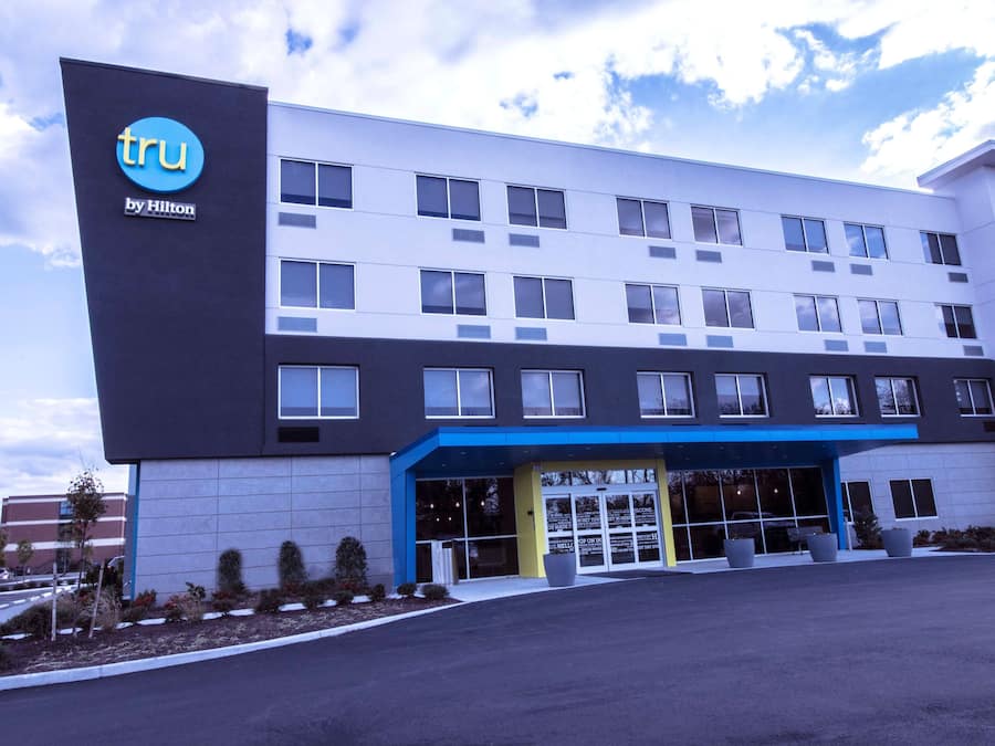 A modern hotel building with a blue and white facade, multiple windows, and a clear sky.
