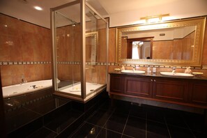 A bathroom with two sinks, a glass-enclosed shower, and a large mirror. - Borgo Don Chisciotte (Modica)