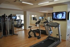 Uma academia com esteiras, elípticos e aparelhos de musculação.