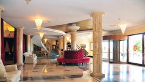 A spacious lobby with marble flooring, a central red seating area, and large columns. - Borgo Don Chisciotte (Modica)