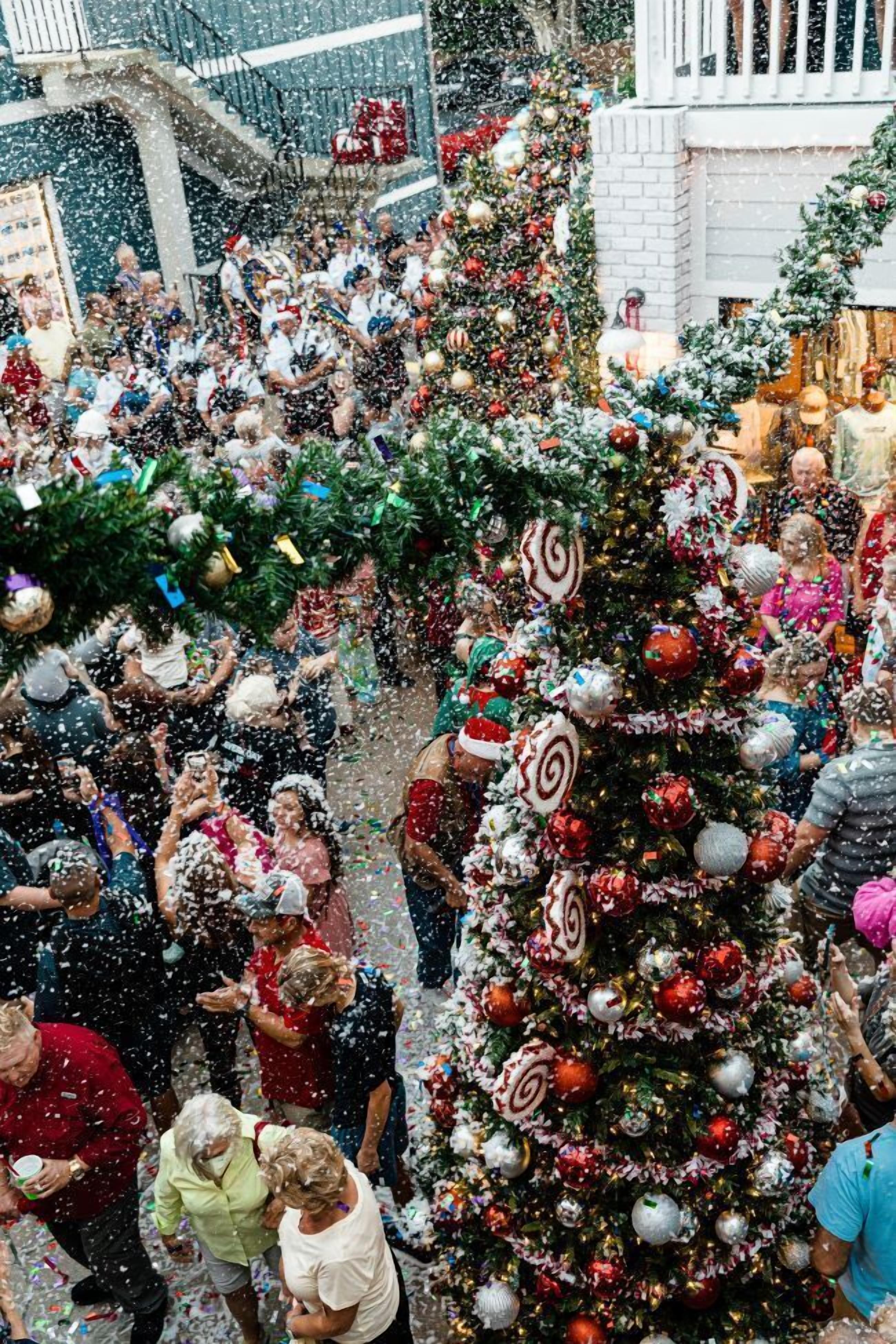 Un espace intérieur bondé, agrémenté d’un grand sapin de Noël décoré et d’autres décorations festives.