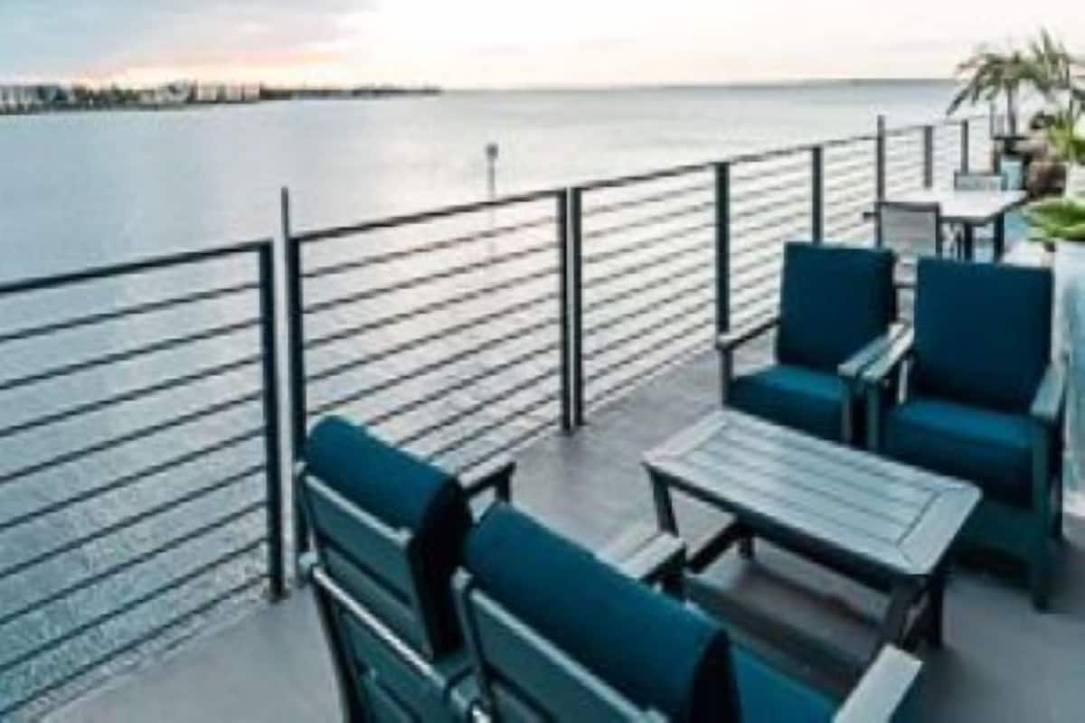 A seaside patio with seating and tables, overlooking the sea.