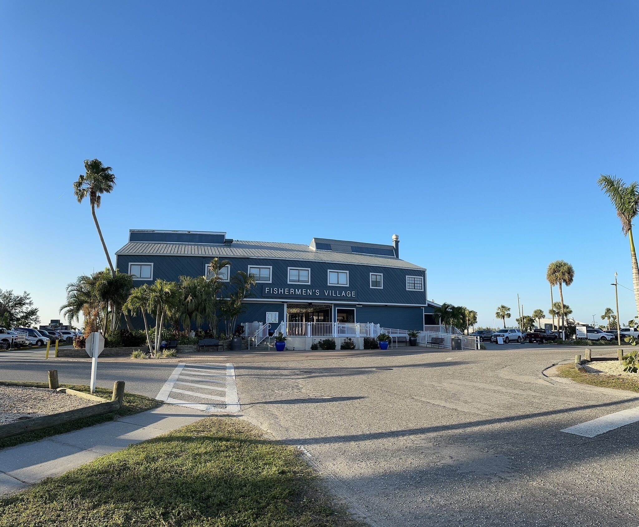 Fishermen's Village with a two-story building, a covered patio, and palm trees.