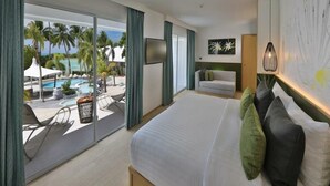 A hotel room with a large bed, a view of a pool and palm trees, a flat-screen TV, and a modern art piece on the wall. - La Vida Samui (Koh Samui)