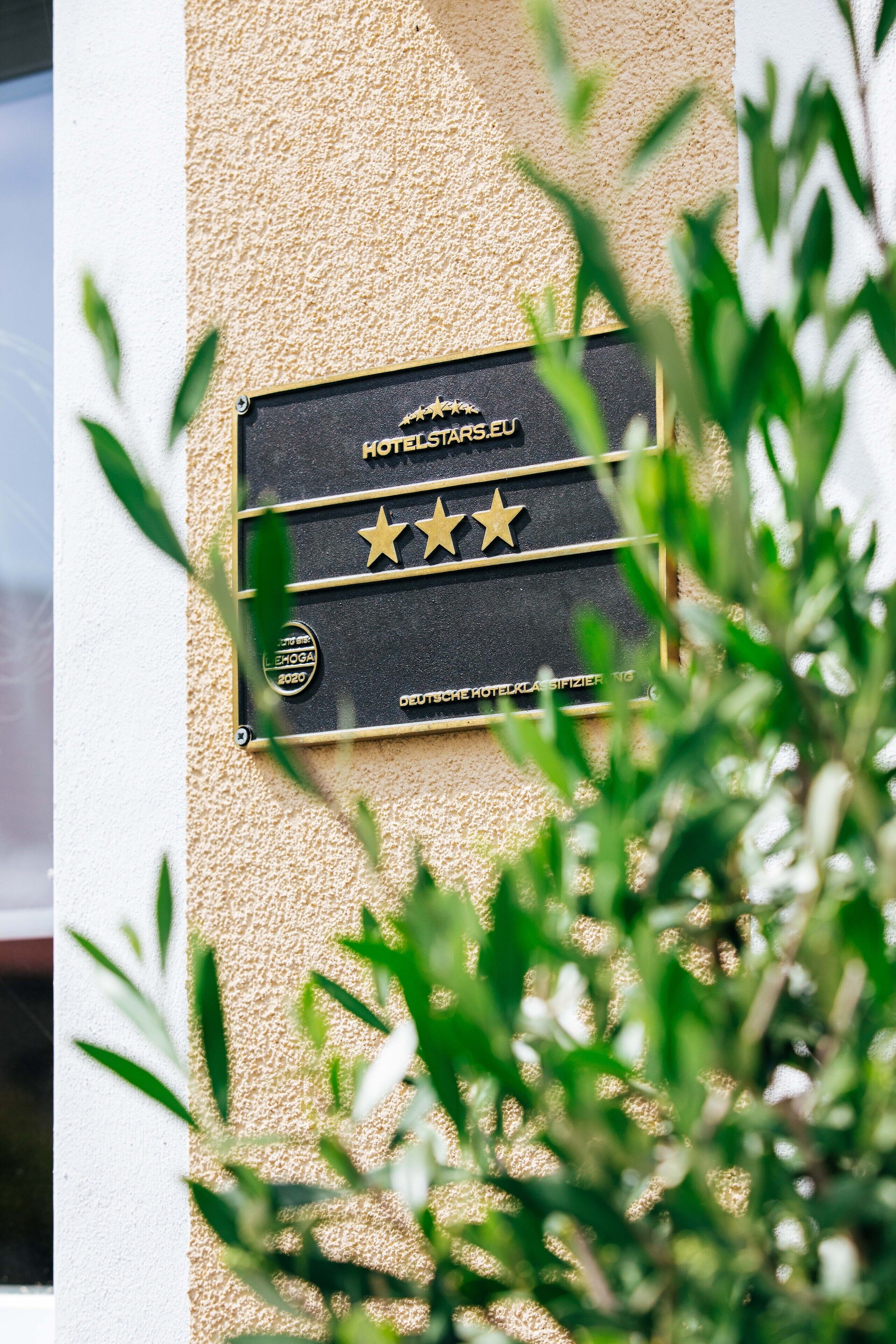 A plaque on a wall with three stars and text indicating a hotel award.