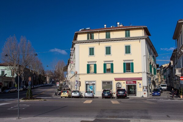 A hotel with a classic facade, multiple windows, and a visible entrance. - Hotel San Marco (Prato)