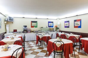 A dining area with checkered flooring, tables with red tablecloths, and metal chairs. - Hotel San Marco (Prato)