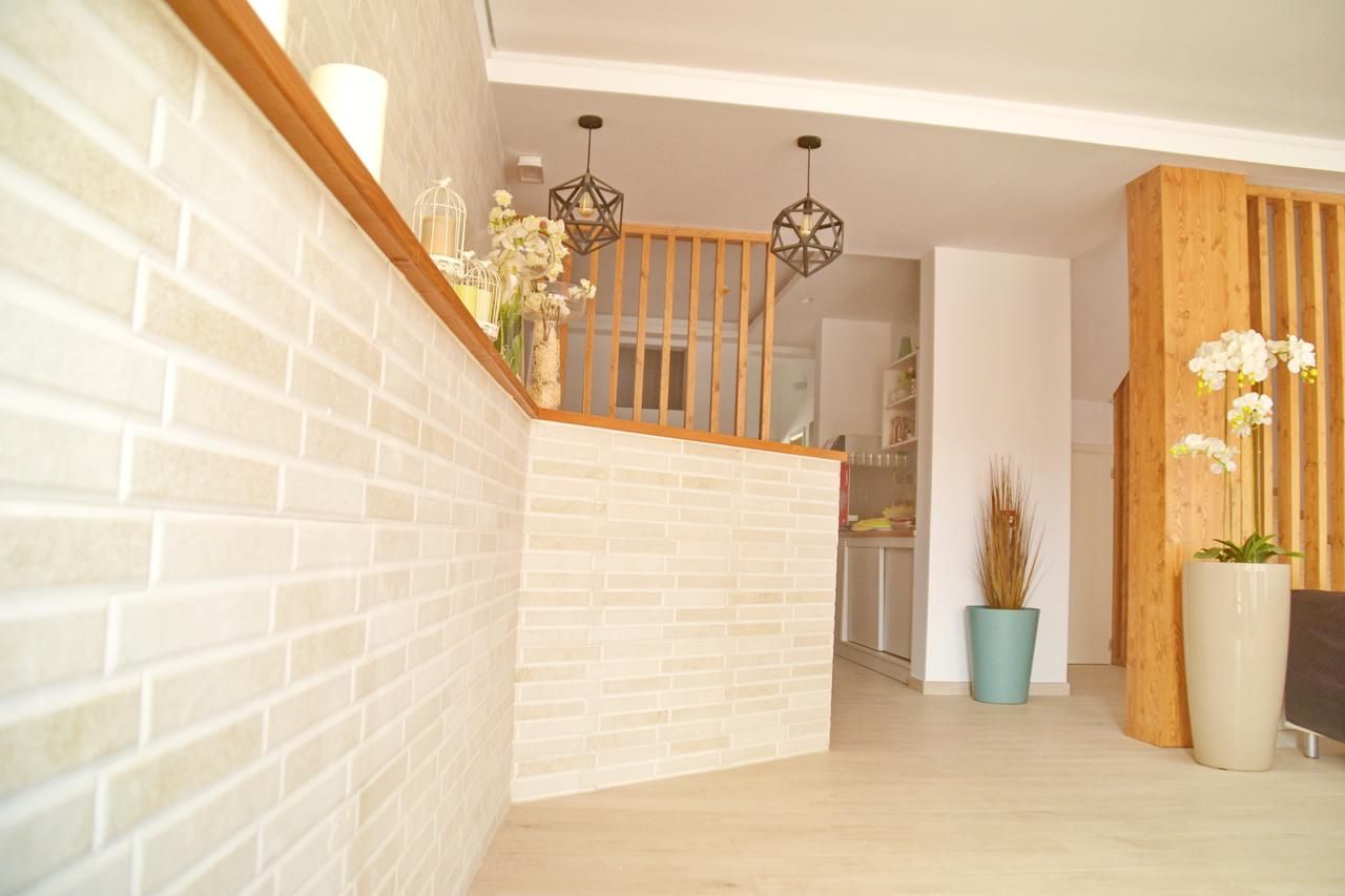 A staircase with a wooden railing, a white brick wall, and a wooden floor.
