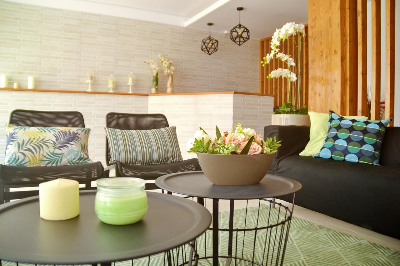 A modern living room with a sofa, two chairs, a coffee table, and decorative items.