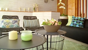 A modern living room with a sofa, two chairs, a coffee table, and decorative items. - Ouril Hotel Julia (Sal)