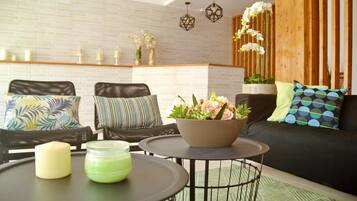 A modern living room with a sofa, two chairs, a coffee table, and decorative items.