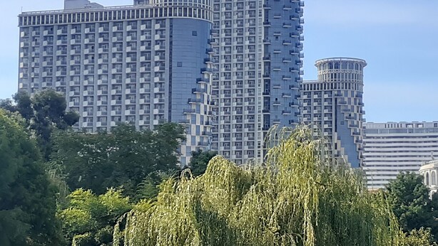 Un edificio de gran altura con un diseño arquitectónico distintivo, que presenta varias secciones cilíndricas y balcones.