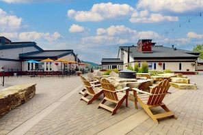 Relax in comfort with Adirondack chairs and tables amidst a serene outdoor setting.