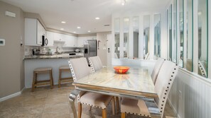 Enjoy meals in the spacious kitchen and dining area, featuring a central island, oven, and comfortable seating.