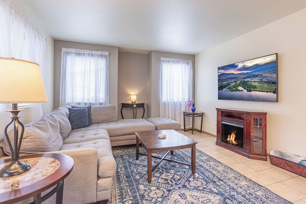 Un salon avec un canapé, une table basse, une cheminée et un tableau au mur.