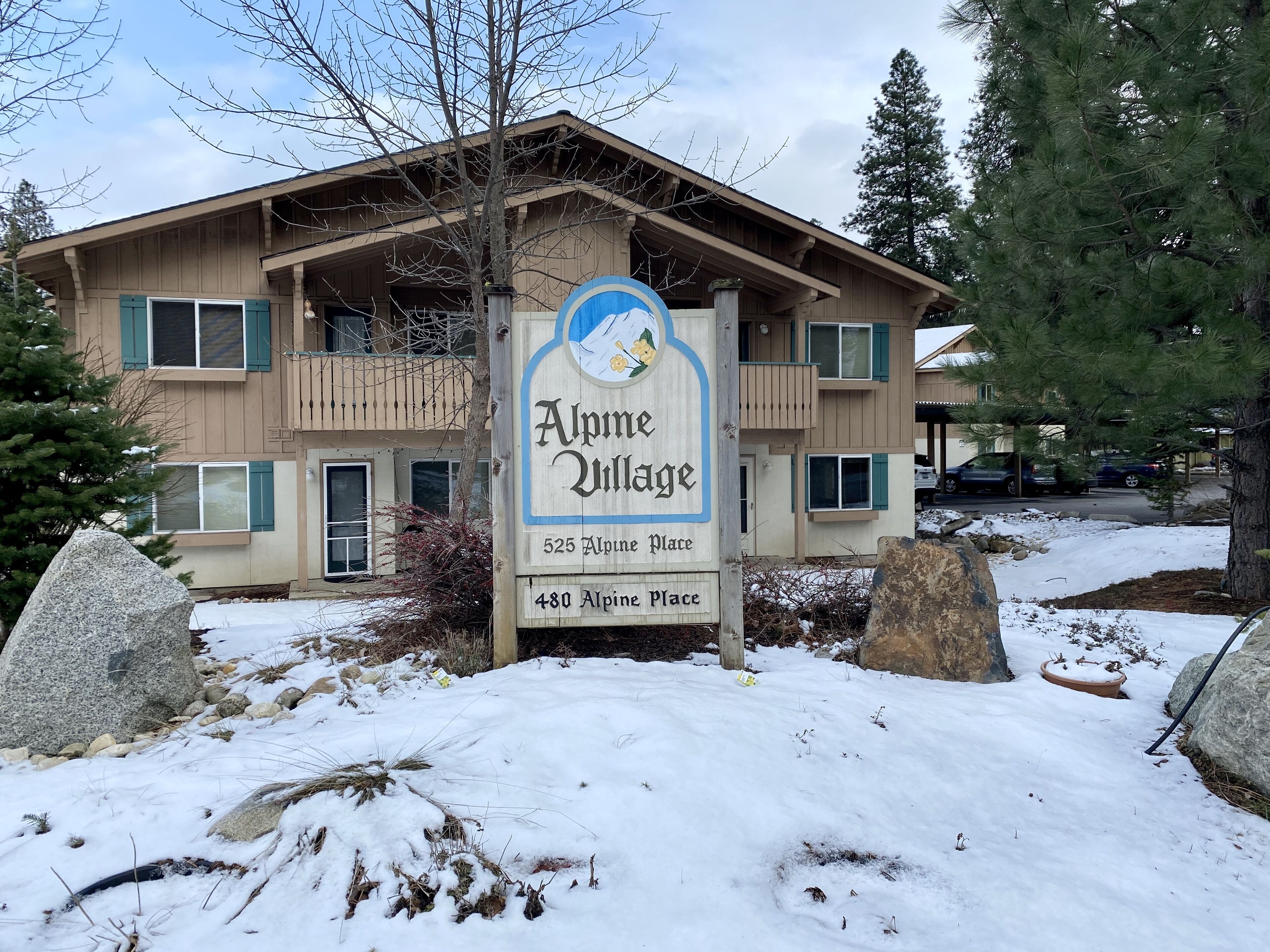 A two-story building with a sign reading 'Alpine Village' and addresses '525 Alpine Place' and '480 Alpine Place'.
