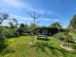 A backyard with a picnic table, a barbecue grill, and a small shed. - Peaceful Apartment in Hüttenrode near Braunlage Ski Area (Blankenburg)