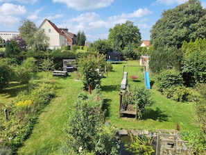 A well-maintained garden with a variety of plants, a small pond, and outdoor furniture.
