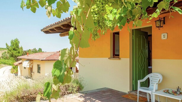 A house with a tiled roof, a green door, and a number '1' sign. - Belvilla by OYO Casa Reale Quattro (Montecalvo Versiggia)