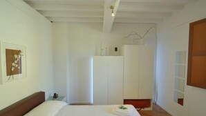 Ein Schlafzimmer mit einem großen Bett, einem Kleiderschrank und einem Nachttisch.