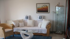 A living room with a sofa, two armchairs, a glass coffee table, a blue rug, a painting on the wall, and a glass cabinet with items. - Peaceful House Only 900m From the sea With Swimming Pool, Bbq, Wifi, Airco (Tar-Vabriga)