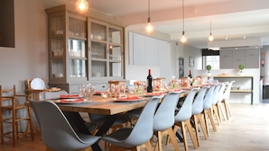 A modern dining area with a long wooden table set for a meal, surrounded by grey chairs. - Peaceful Forest Stay in Gesves (Gesves)