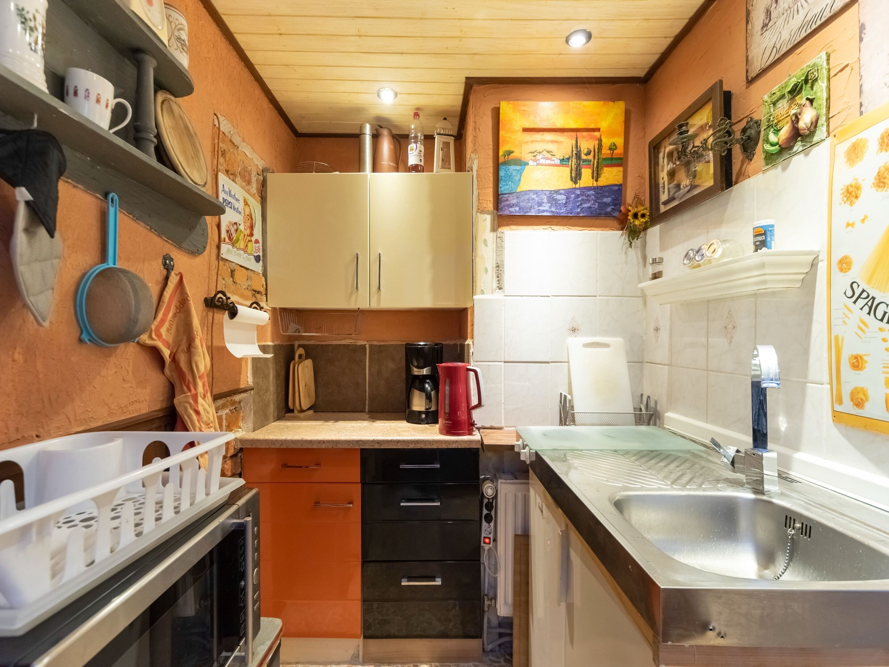 A compact kitchen with a sink, stove, and various kitchen appliances.