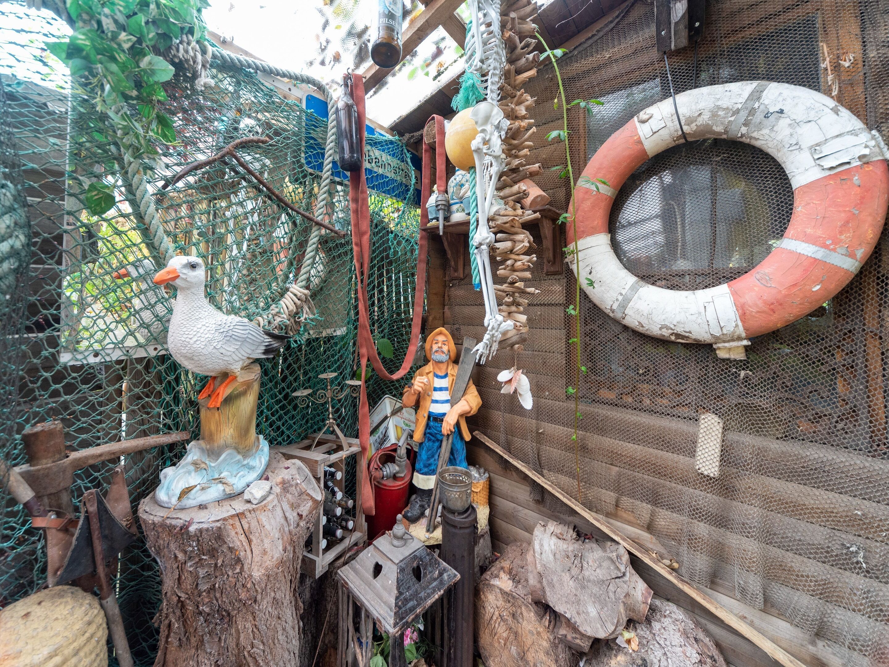 A rustic outdoor setting with a wooden structure, a rope swing, and a life preserver.