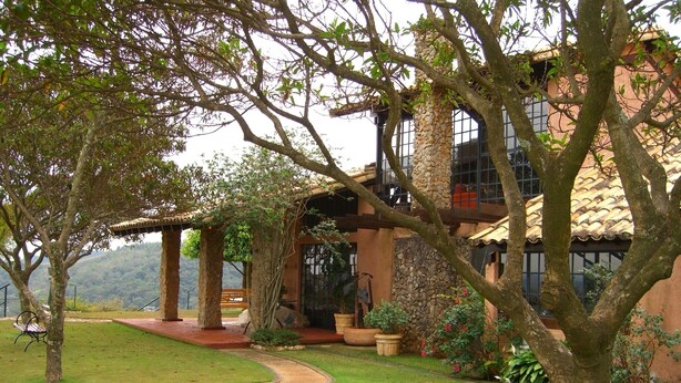 A building with stone pillars, a covered patio, and a view of the surrounding landscape. - Chácara Vale da Esperança 40 minutes from São Paulo with Fiber Internet (Mairinque)