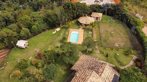 A residential property with a swimming pool, a tennis court, and a small house. - Chácara Vale da Esperança 40 minutes from São Paulo with Fiber Internet (Mairinque)