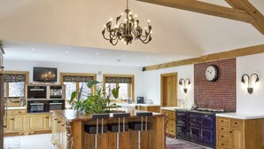 A spacious kitchen with a central island, wooden cabinets, a built-in oven, and a large chandelier. - 5 bedroom accommodation in Stalmine, near Poulton-le-Flyde (Stalmine, near Poulton-le-Flyde)