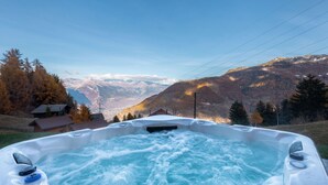 A hot tub with a view of mountains and a house in the background. - Chalet Belle Roche | Recently renovated | Jacuzzi (Riddes)