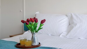 A bed with white linens, a tray with glasses of a yellow beverage, and a vase with red tulips. - 4 bedroom accommodation in Goathland (Goathland)