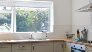 A kitchen with a window, sink, cabinets, and an oven. - 4 bedroom accommodation in Goathland (Goathland)