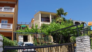 A residential building with a balcony, a car parked in front, and a sign indicating a boutique hotel. - Boutique Apartment in Pjescana Uvala With Balcony (Medulin)