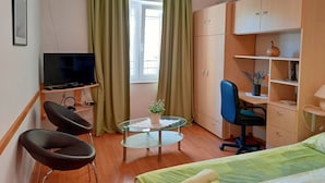 A compact room with a bed, a desk with a chair, a television on a stand, and a wardrobe. - Boutique Apartment in Pjescana Uvala With Balcony (Medulin)