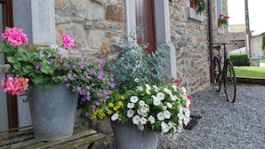 Ein Steinhaus mit Blumenkästen vor der Fassade.