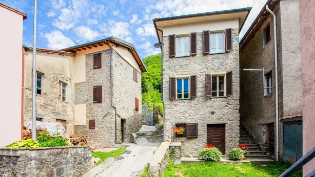 A narrow street with stone buildings, a metal staircase, and a small garden area. - Holiday Home in Pascoso Near Forest (Pescaglia)