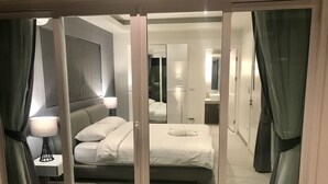 Une chambre à coucher moderne avec un grand lit, des lampes de chevet et un miroir.