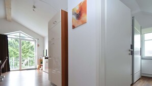 A spacious room with a large sliding glass door leading to a balcony, a wooden floor, and a white wardrobe. - Wohnung in Willingen Nahe Ettelsberg-bahn (Willingen)
