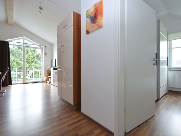 A spacious room with a large sliding glass door leading to a balcony, a wooden floor, and a white wardrobe. - Wohnung in Willingen Nahe Ettelsberg-bahn (Willingen)
