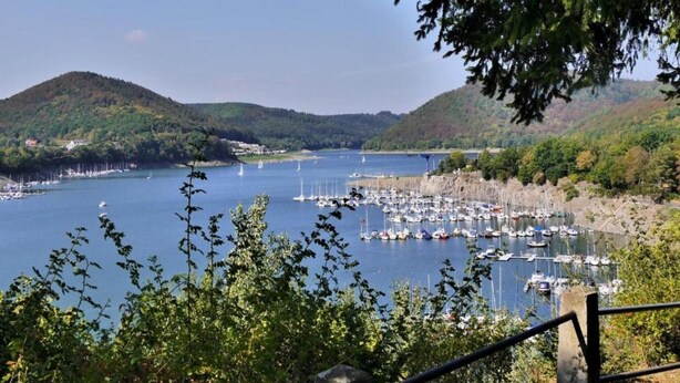 A marina with boats docked, surrounded by hills and trees. - Wohnung in Willingen Nahe Ettelsberg-bahn (Willingen)