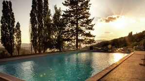 A rectangular swimming pool with a tiled edge, surrounded by a pebble surface. - Belvilla by OYO Santa Cecilia (Rufina)