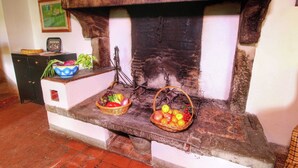 A fireplace with two baskets of fruit and vegetables on a white mantelpiece. - Belvilla by OYO Santa Cecilia (Rufina)