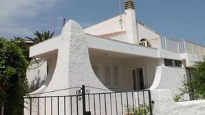 A modern house with a white exterior, a balcony, and a chimney. - Belvilla by OYO Villa Eirene (Syracuse)