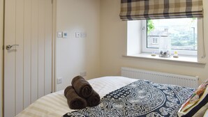 A bedroom with a bed, a window with a view, a radiator, and a door. - 2 bedroom accommodation in Bamford, near Hope Valley (Bamford, near Hope Valley)